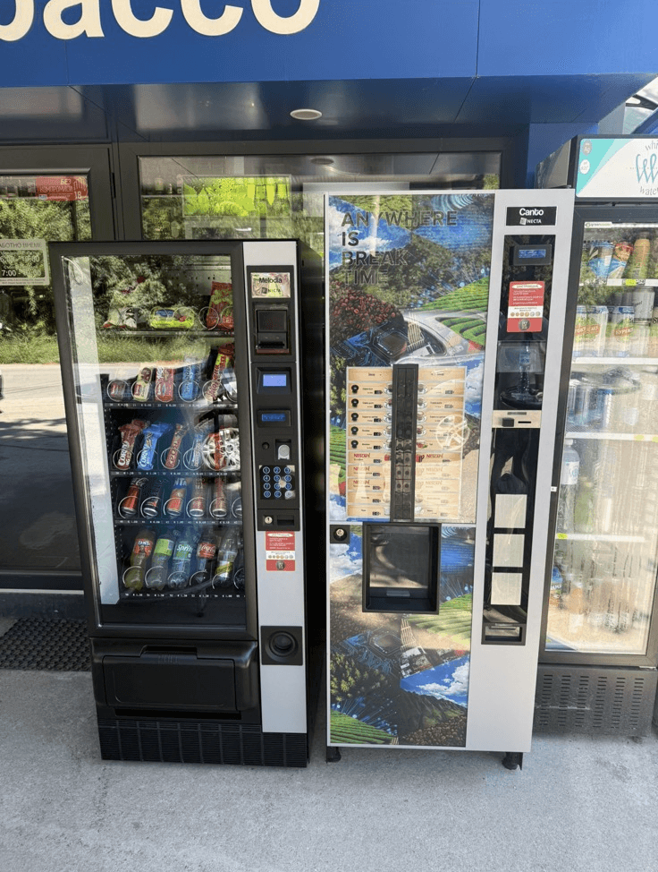 Un distributeur de snacks et un distributeur de café, installés et remplis devant un commerce